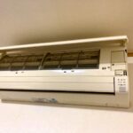 エアコンのフィルターを掃除しようとしている人